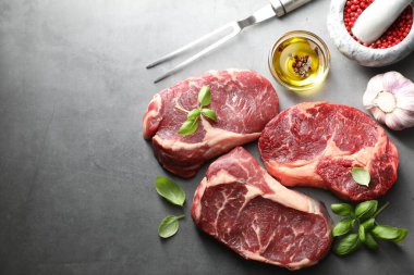 Çiğ et, baharat ve çatal parçaları gri masada, düz yerde. Metin için boşluk