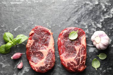 Koyu masa üzerinde çiğ et ve baharat parçaları, düz. Metin için boşluk