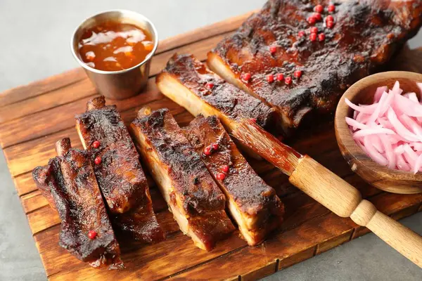 Lezzetli kaburga, soğan, sos ve fırça.