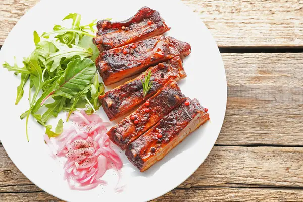 Lezzetli domuz pirzolası, roka ve soğan ahşap masa, üst manzara.