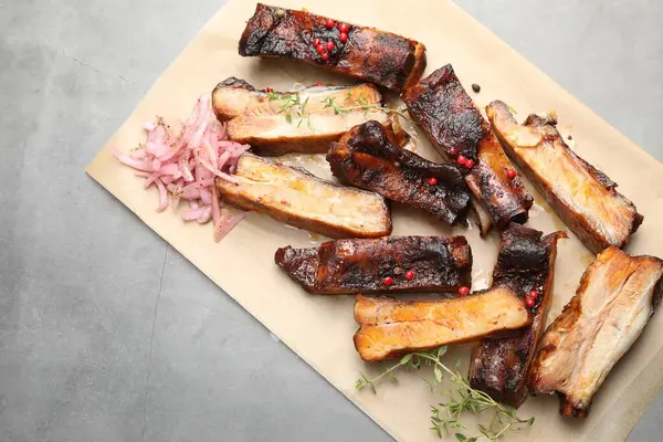 Lezzetli domuz pirzolası, kekik ve soğanlı gri desenli masa, üst manzara. Metin için boşluk