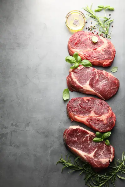 Çiğ et ve baharat parçaları gri masada, düz yerde. Metin için boşluk