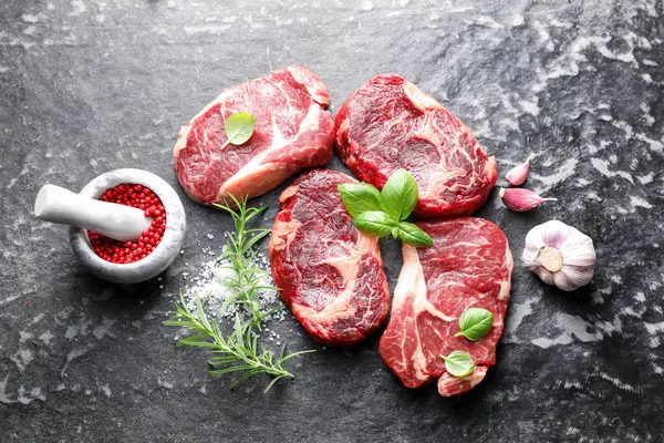 Koyu masada çiğ et ve baharat parçaları, düz yatıyordu.