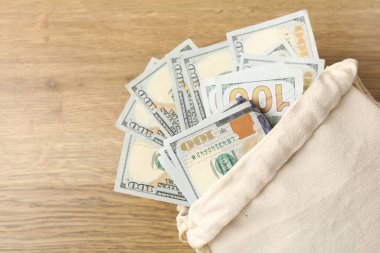 Tahta masanın üzerinde bir sürü banknot olan çanta, üst manzara. Metin için boşluk