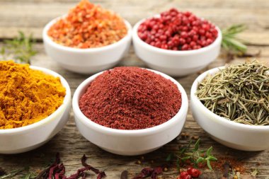 Ahşap masada farklı aromatik baharatlar, yakın plan.