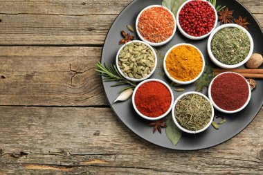 Ahşap masada değişik aromatik baharatlar, üst manzara. Metin için boşluk