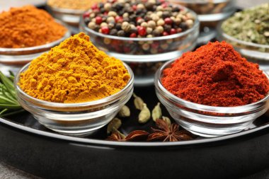 Açık gri masada farklı aromatik baharatlar, yakın plan.