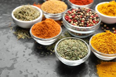 Karanlık masadaki kaselerde farklı aromatik baharatlar, yakın plan. Metin için boşluk