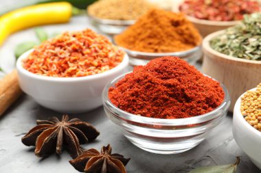 Gri masada farklı aromatik baharatlar, yakın plan.