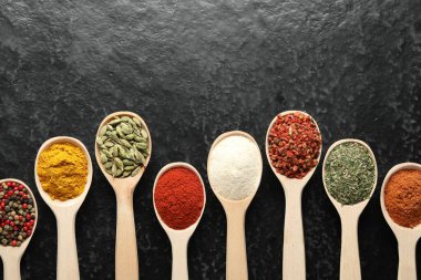 Siyah masadaki kaşıklarda bir sürü farklı baharat var. Metin için boşluk