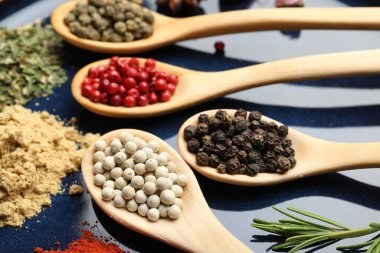 Tabaktaki kaşıklardaki farklı aromatik baharatlar, yakın plan.