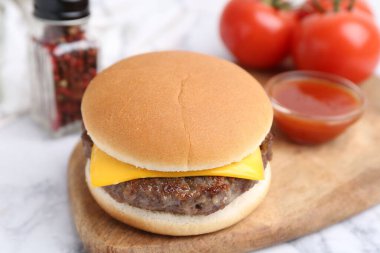 Lezzetli çizburger beyaz mermer masada, yakın plan.