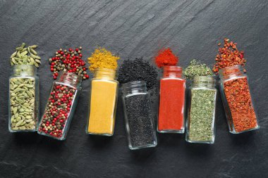 Siyah masadaki kavanozlarda farklı aromatik baharatlar var.