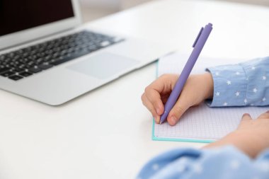 Küçük kız ev ödevlerini içeride yapıyor, yakın plan.