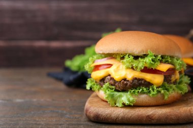 Ahşap masada soslu lezzetli bir çizburger, yakın plan. Metin için boşluk