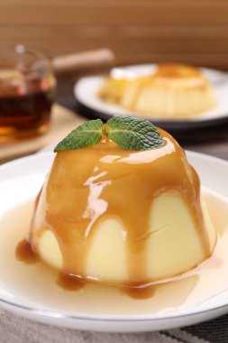 Karamel soslu lezzetli puding ve nane şekeri, yakın plan.