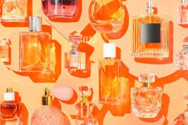 Bej arka planda farklı lüks parfümler, düz yatış