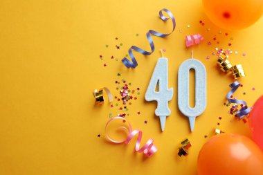 40. yaş günü. Numara şekilli mumlar ve turuncu arka planda parti dekorasyonu. Metin için boşluk