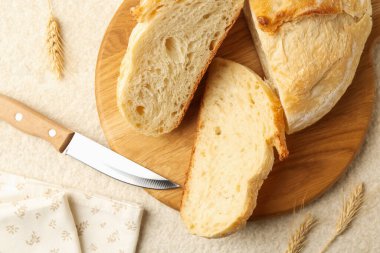 Taze ekmek dilimleri, dikenler ve bıçak açık dokulu masa, düz uzanmış.