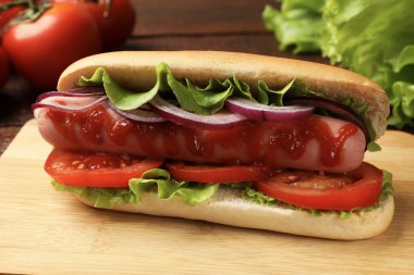 Lezzetli sosisli, domates, soğan, marul ve ketçap, yakın plan.