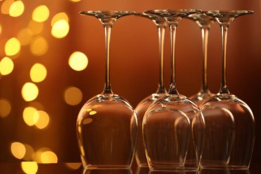 Bulanık ışıklara karşı cam ayna yüzeyinde birçok temiz bardak var. Bokeh etkisi