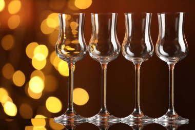 Bulanık ışıklara karşı cam ayna yüzeyinde birçok temiz bardak var. Bokeh etkisi