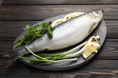 Ahşap masada tuzlanmış ringa balığı ve baharat.