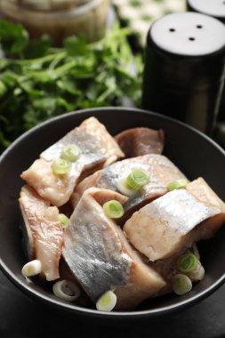 Siyah masada yeşil soğanlı lezzetli ringa balıkları, yakın plan.