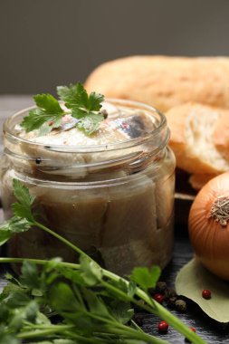 Baharatlı lezzetli ringa balıkları ve siyah masada maydanoz, yakın plan.