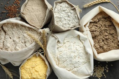 Gri masadaki poşetlerdeki farklı un türleri, düz yatıyordu.