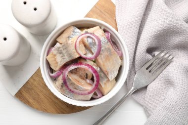 Beyaz masadaki soğanlı lezzetli ringa balıkları.