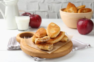 Lezzetli kızarmış pirinçler (doldurulmuş turtalar) ve beyaz ahşap masada elmalar, yakın plan.
