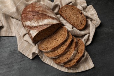 Taze ekmek parçaları siyah masanın üstünde, düz yatıyordu.