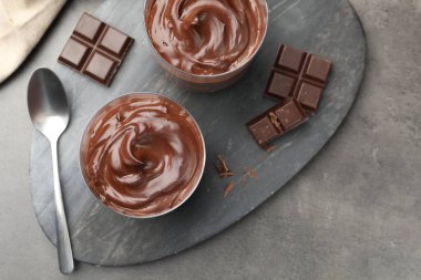 Lezzetli puding ve çikolata parçaları gri masada, düz yatıyordu.