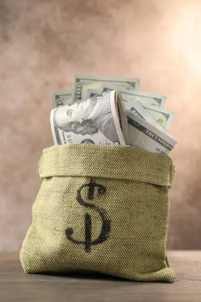 Tahta masanın üzerinde bir sürü banknot olan çanta.