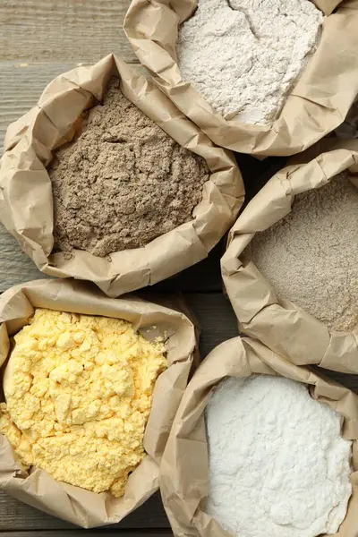 Tahta masadaki kağıt torbalarda farklı türde un var.