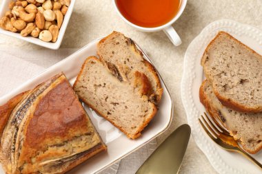 Muzlu ekmeği fındıklı kes ve açık gri masada çay, düz yat.