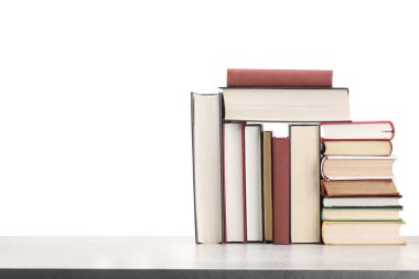 Açık gri masadaki eski kitaplar beyaz arkaplana karşı