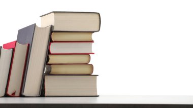 Açık gri masadaki eski kitaplar beyaz arkaplana karşı