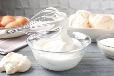 Krem şantili çırpma çırpma ve gri ahşap masadaki diğer malzemeler, yakın plan. Kurabiye pişiriyorum.