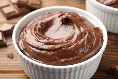 Tahta masadaki kaselerde çikolatalı puding, yakın plan.