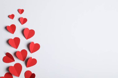 Açık gri arkaplanda bir sürü kağıt kalp, düz bir zemin. Metin için boşluk