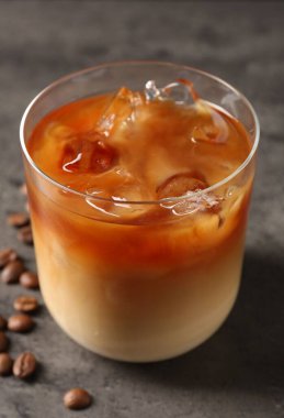 Gri masada lezzetli buzlu kahve ve fasulye, yakın plan.