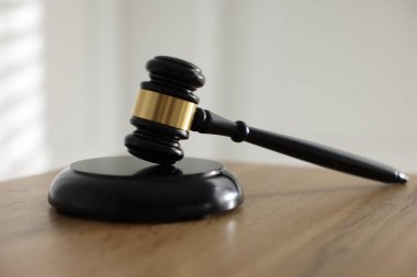 Hakimin tokmağı ahşap masada, arka planda ışığa karşı, yakın plan.