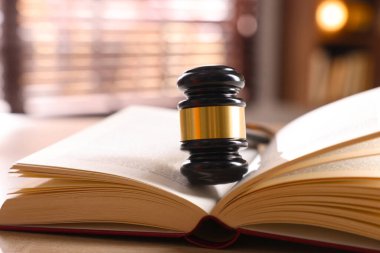 Yargıç tokmağı ve kitabı kapalı bir masa üzerinde, yakın plan.