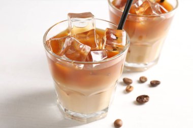 Lezzetli buzlu kahve ve fasulyeler beyaz masada, yakın plan.