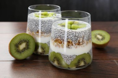 Chia tohumlu lezzetli tatlı, yoğurt, tahıl gevreği ve ahşap masada kivi, yakın plan. Süper yemek.