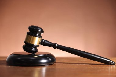 Hakimin tokmağı ve ses bloğu açık kahverengi arka plana karşı ahşap masada.