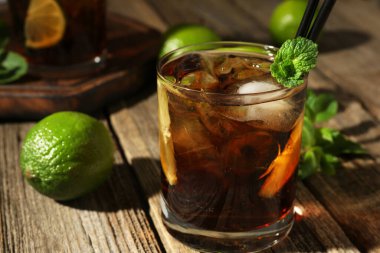 Küba libre kokteylini ahşap masada nane şekeri ile tazeliyorum.