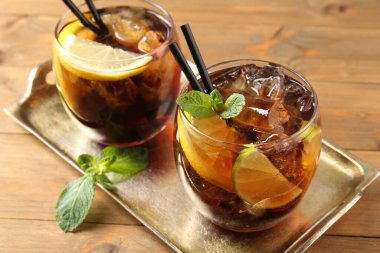 Küba libre kokteylini ahşap masada nane şekeri ile tazeliyorum.